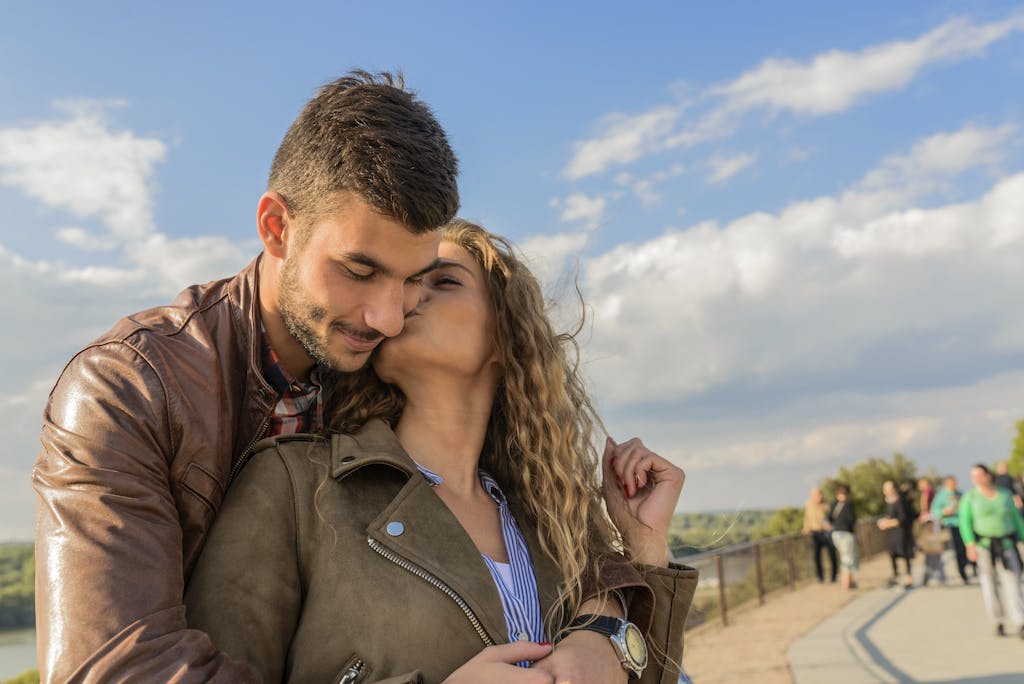 A loving couple embraces under a clear sky, showcasing romance and togetherness.