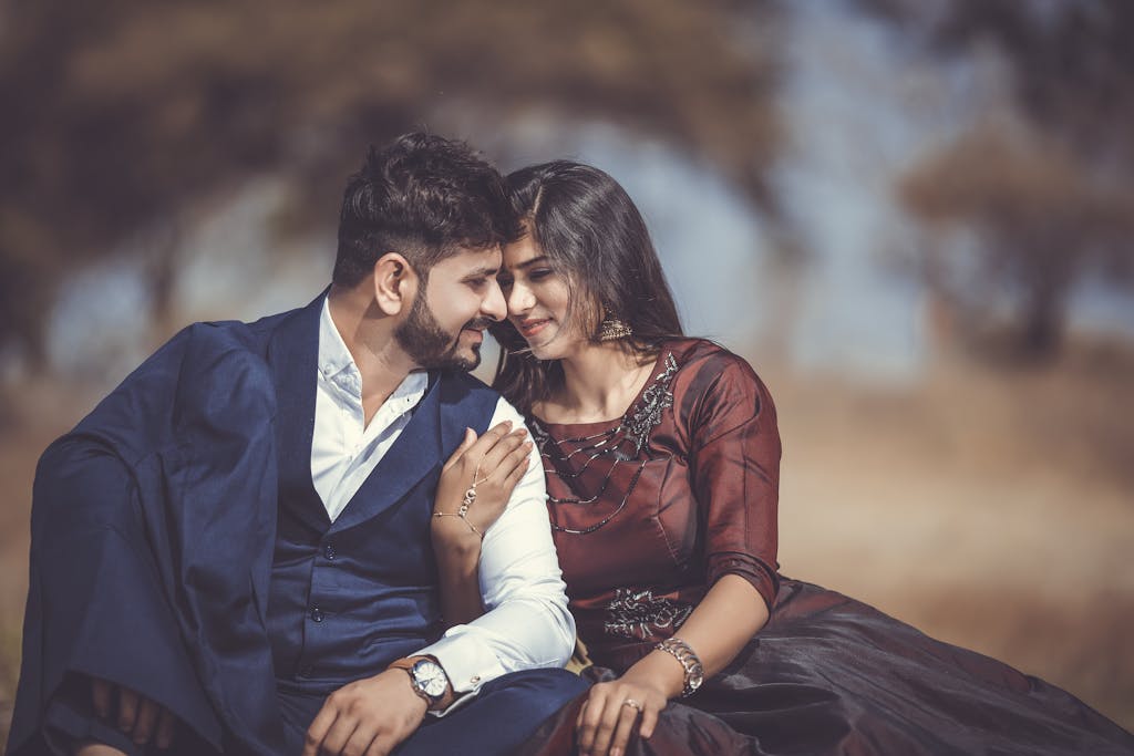 A loving couple sharing a tender moment outdoors, highlighting their romantic connection and stylish attire.